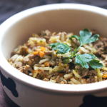 Dog food bowl filled with fresh food-based ingredients including meat, rice, and vegetables