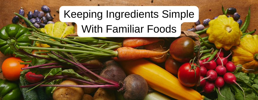 A variety of fresh vegetables on a wooden surface with overlaid text reading “Keeping ingredients simple with familiar foods."